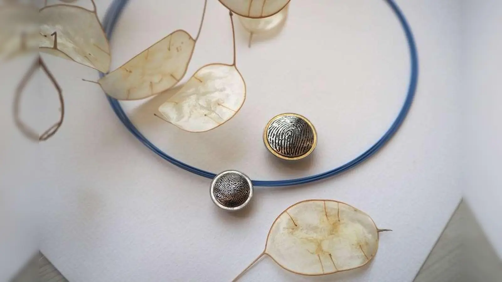 Anhänger erinnern an Verstorbene. In geheime Kammern der Schmuckstücke können auch Asche oder Haare eingeschlossen werden.<br><br>Anhänger erinnern an Verstorbene – zum Beispiel, indem sie ihren Fingerabdruck zeigen. In geheime Kammern der Schmuckstücke können auch Asche oder Haare eingeschlossen werden.<br><br><br> (Foto: djd/www.nanogermany.de)