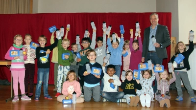 Erstklasskinder der Sankt-Korbinian-Grundschule und Dominik Schwegler (Geschäftsführer Freisinger Stadtwerke) freuen sich über die neuen Trinkflaschen und Brotzeitboxen. (Foto: Stadtwerke Freising)