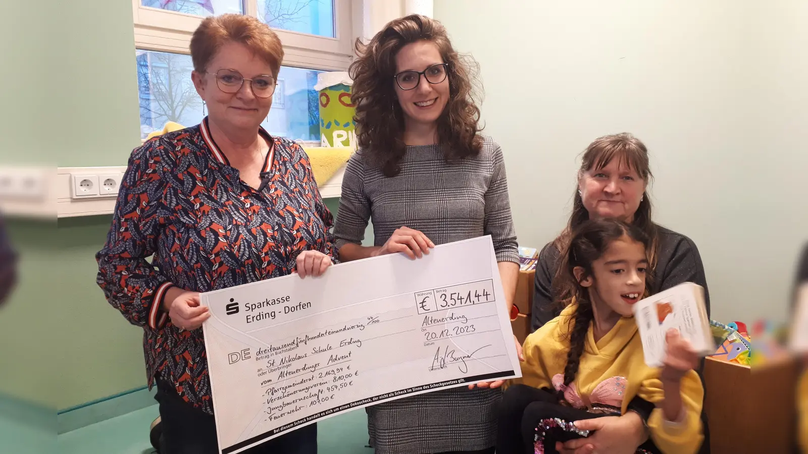 Rosemarie Jaletzke (Leitung Heilpädagogische Tagesstätte), Anna-Lisa Burgmair (Pfarrgemeinderat) und Marion Stöcker (Erzieherin) mit Emily (v.l.) freuen sich über die Spende. (Foto: Pfarrgemeinderat)