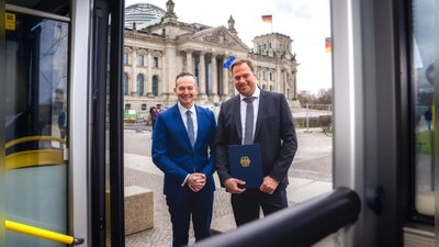 Förderbescheid übergeben: Bundesverkehrsminister Volker Wissing (links) und der Geschäftsführer der AeroGround Flughafen München GmbH, Helmut Ehrnstraßer, vor dem Reichstag in Berlin. (Foto: Basti Wöhl/BMDV)
