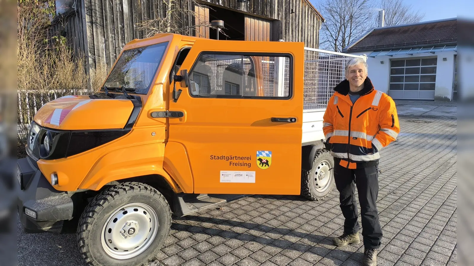 Marco Gasperini, Leiter der Stadtgärtnerei, freut sich über die Verstärkung des Fuhrparks mit dem neuen E-Dreiachskipplaster. (Foto: Stadt Freising)