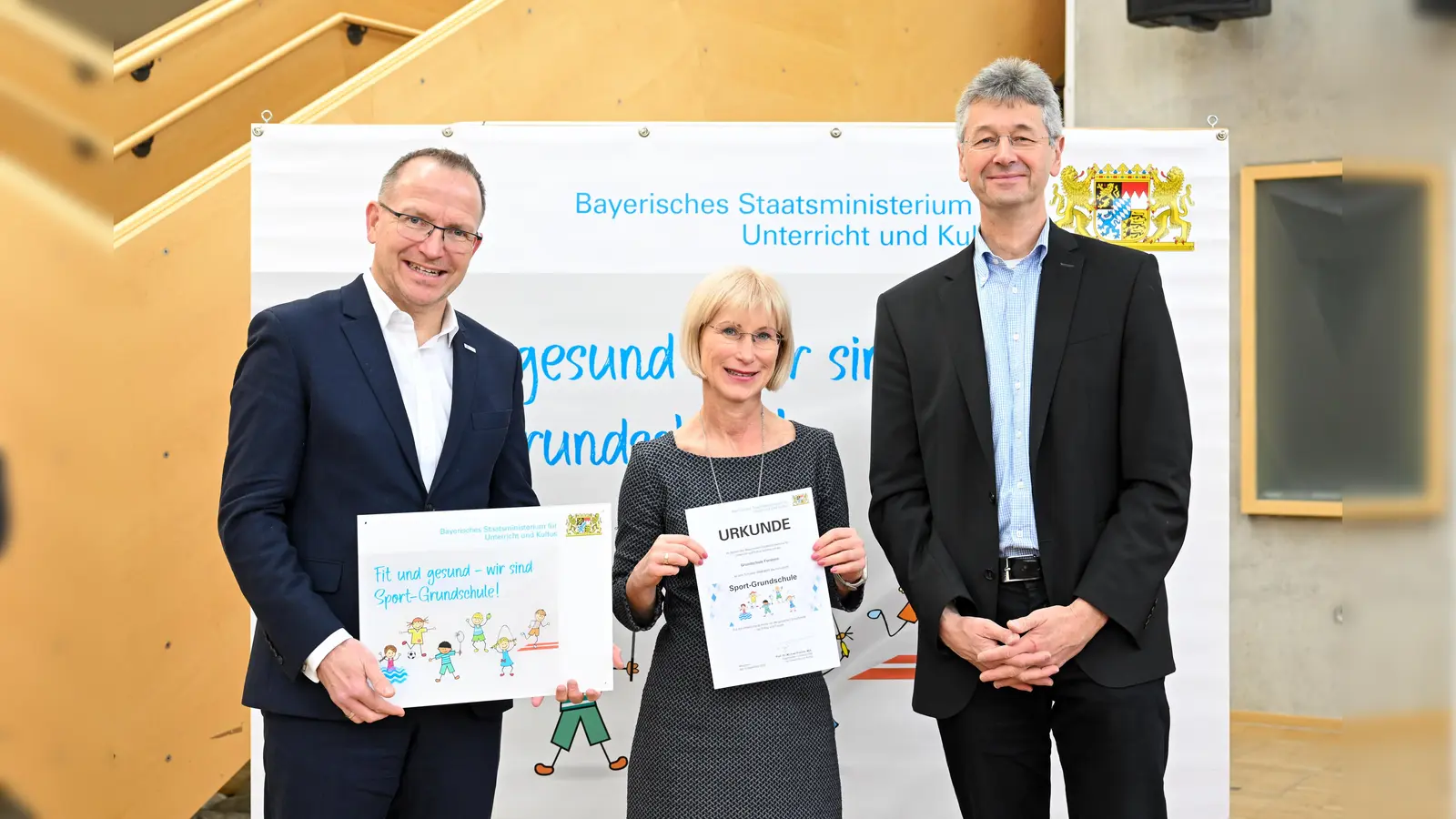 Auszeichnung für die Grundschule Forstern: Kultusminister Prof. Dr. Michael Piazolo (r.), BLSV-Präsident Jörg Ammon (l.) sowie Schulleiterin Annett Taubert. (Foto: Tobias Hase / stmuk)