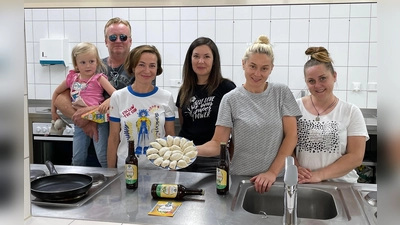 Blick in die Küche (von links): Christian	Hermann	mit	Töchterchen	Marie und	Iryna	hatten	die	Idee,	die	Besucher	des	Bierfestivals	mit	der	ukrainischen	Spezialität	Vareniki	vertraut	zu	machen,	die	derzeit	von	geflüchteten	Ukrainerinnen	Alona,	Anna	und	Elena	zubereitet werden.	 (Foto: Hallertauer	Bierfestival)