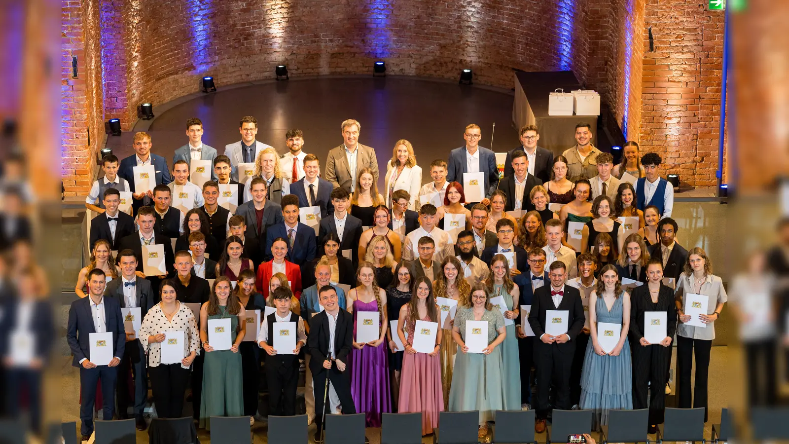 Gruppenbild mit allen Geehrten, Dr. Markus Söder, MdL, Anna Stolz, MdL (Bayerische Staatsministerin für Unterricht und Kultus) in der Allerheiligen-Hofkirche, München. (Foto: Jens Hartmann/StMUK)