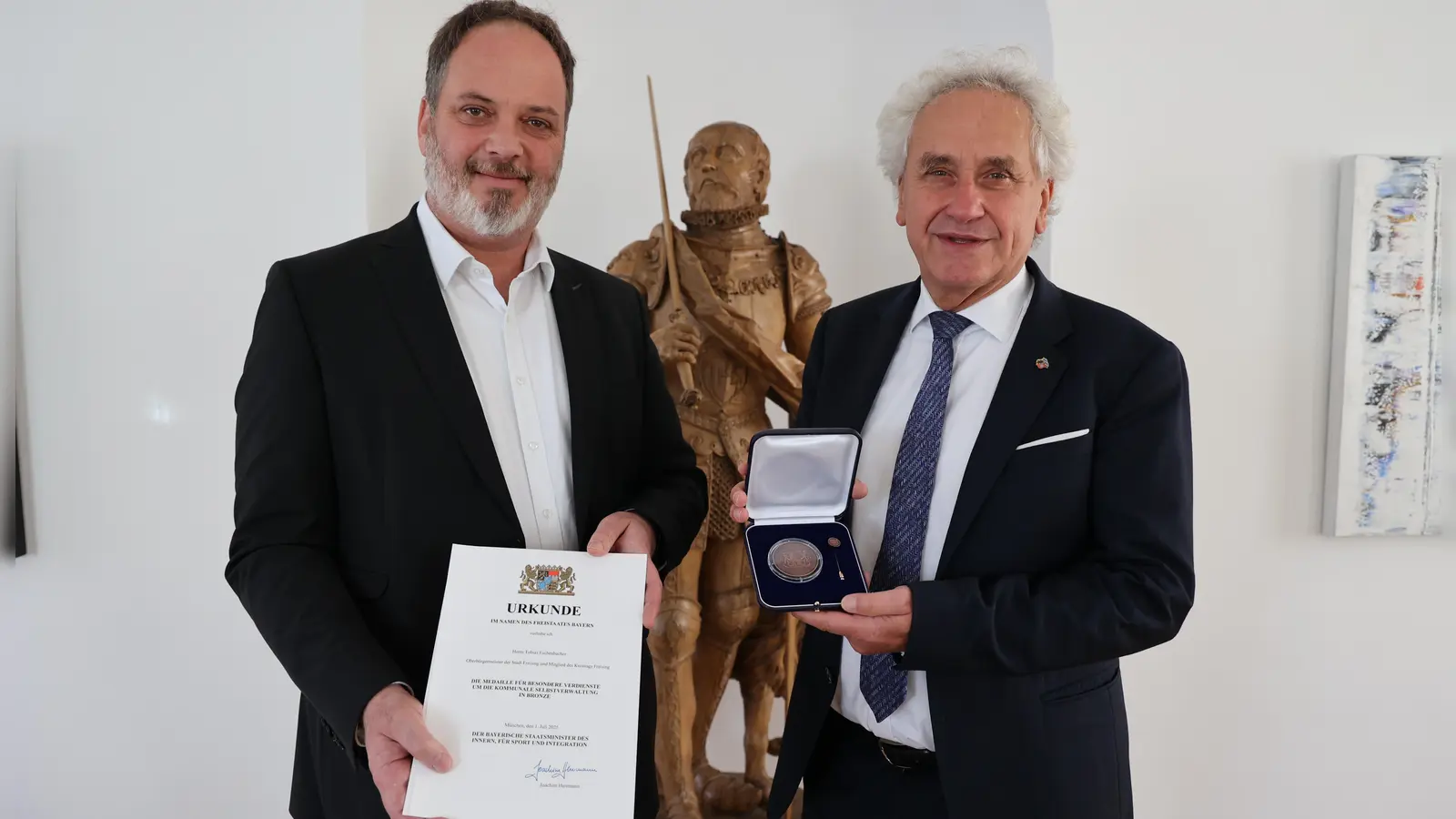 Landrat Helmut Petz (r.) überreicht OB Tobias Eschenbacher die Kommunale Verdienstmedaille in Bronze. (Foto: LRA Freising)