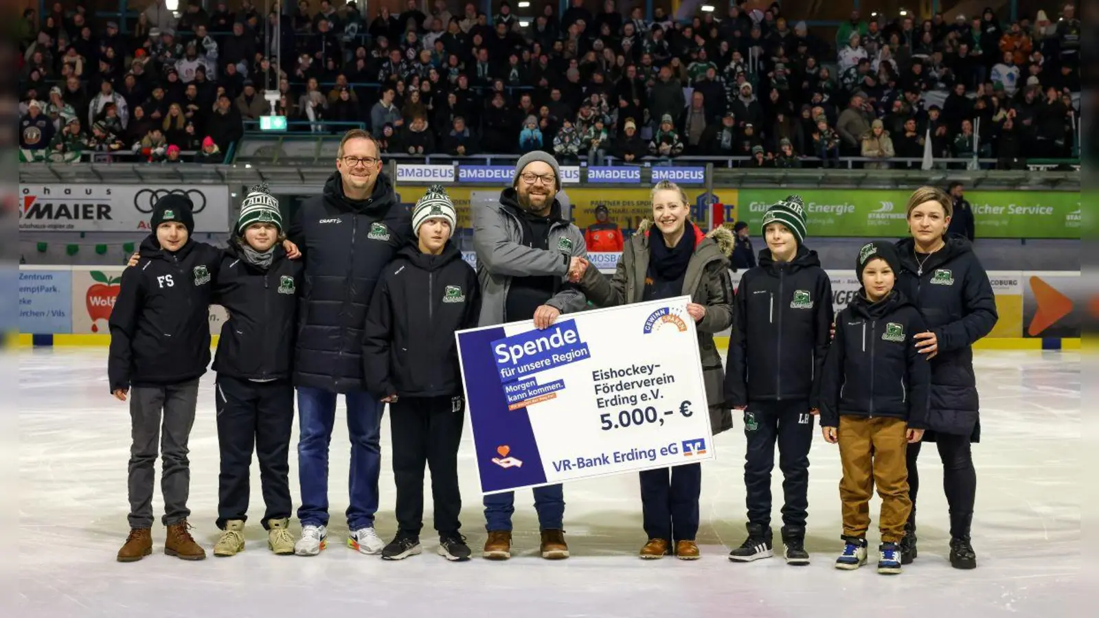 Spieler der U11 und U13 freuen sich gemeinsam mit (v.l.) Jan Sigel (Betreuer U13, Organisationsleiter Reise Schweden), Martin Bauer (Vorstand Eishockey-Förderverein Erding e.V.), Daniela Hüniger (Leiterin Marketing VR Bank Erding eG) sowie Tanja Poetzel (Betreuerin U11) über die großzügige Spende der VR Bank Erding eG. (Foto: Christian Riedel / Gladiators)